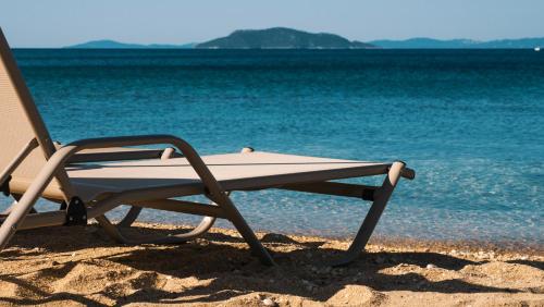 a beach chair sitting on the sand on the beach at Casa Bloo Adults Only in Elia