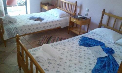 a bedroom with two beds and a table with a night stand at Elizabeth Hotel in Kallithea Halkidikis