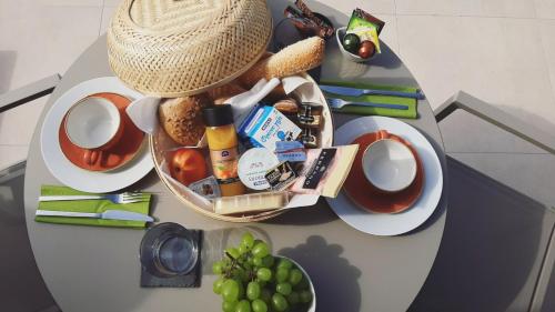 a table with a basket of food and a hat on it at Cavo Delea Villas & Suites in Possidi