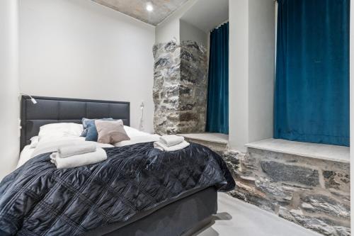 a bedroom with a large bed with blue curtains at Aalesund City Apartment in Ålesund