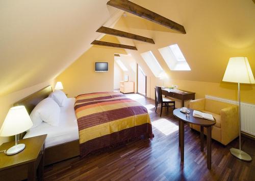 ein Schlafzimmer mit einem Bett und einem Schreibtisch in einem Zimmer in der Unterkunft Sporer Stadthotel Bad Radkersburg in Bad Radkersburg