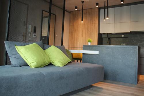 a blue couch with two yellow pillows in a kitchen at ALEKSANDRA 2 - CONCRETE in Kielce