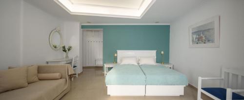 a living room with a bed and a couch at Villa Renos Hotel in Fira