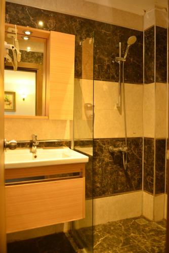 ein Bad mit einem Waschbecken und einer Dusche in der Unterkunft Pure Diamond Hotel in Antalya