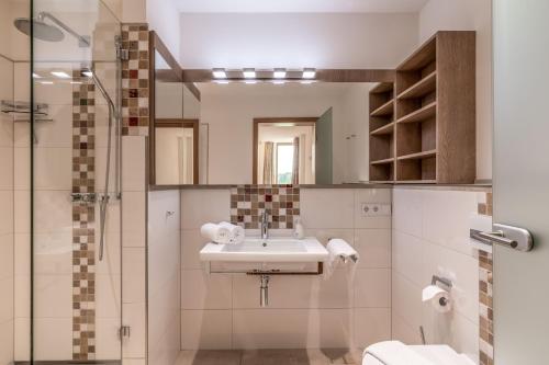 a bathroom with a sink and a shower at Lebensart am See in Bad Endorf