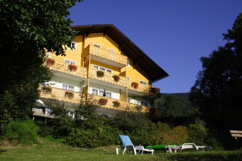 a yellow building with chairs in front of it at Seehaus Karantanien am Ossiacher See in Ossiach