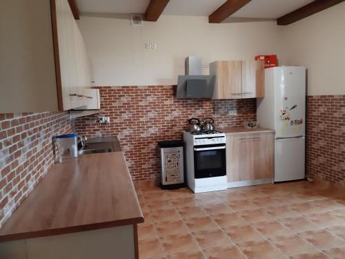 a kitchen with a stove and a refrigerator at Dom letniskowy Sieraków in Sieraków