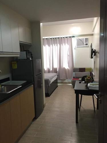 a kitchen and a living room with a couch at Furnished Studio Megaworld 7M in Iloilo City