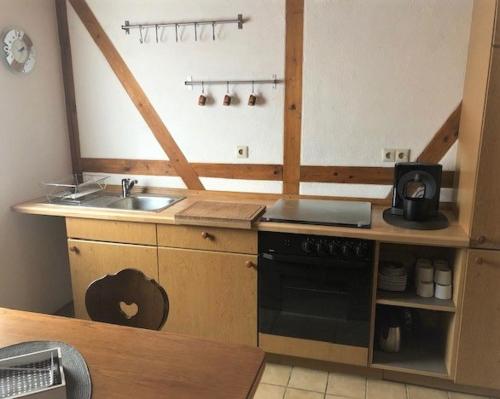 a small kitchen with a sink and a stove at FeWo Stubenhocker in Pleisweiler-Oberhofen
