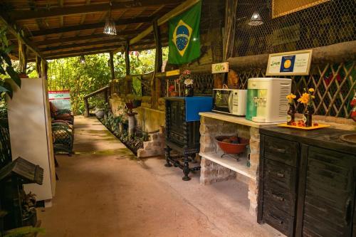 a room with a kitchen with a counter and a refrigerator at Saíra Recanto de Serra in Mulungu