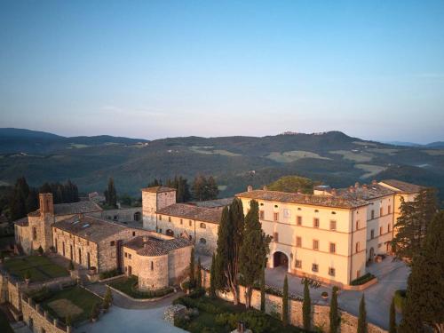 an aerial view of a building with mountains in the background at Castello di Casole, A Belmond Hotel, Tuscany in Casole dʼElsa
