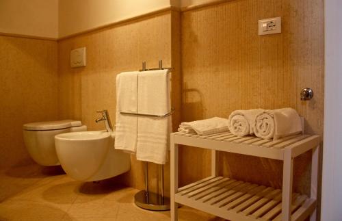 a bathroom with a toilet and a sink and towels at Suite Pasqualigo - Feltre tra Venezia e le Dolomiti in Feltre