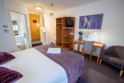 Redwings Lodge Solihull في سوليهال: غرفة في الفندق بها سرير ومكتب وبه جهاز كمبيوتر