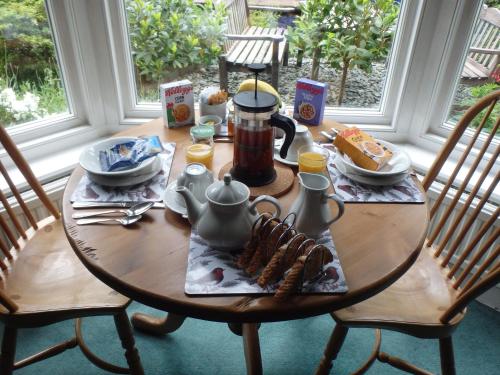 a wooden table with breakfast food on it at Haisthorpe Guest House in Windermere