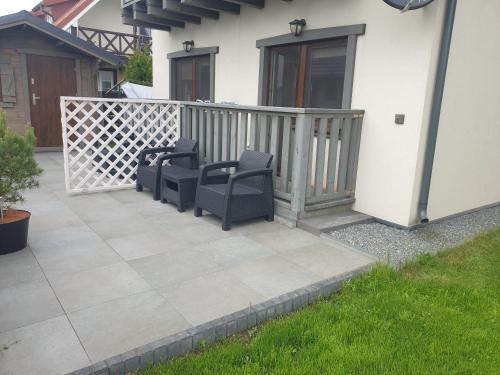 a patio with two chairs and a fence at Los Reyes II - klimatyzowane pokoje in Krynica Morska