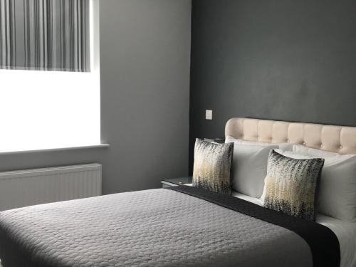 a bedroom with a white bed with pillows and a window at The Old School House Rooms in Waterbeach