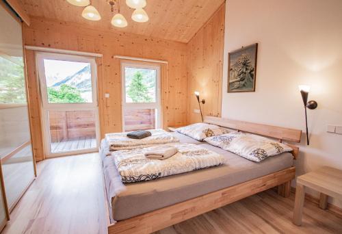 1 Schlafzimmer mit 2 Betten und 2 Fenstern in der Unterkunft Gschnitzerhof in Gschnitz