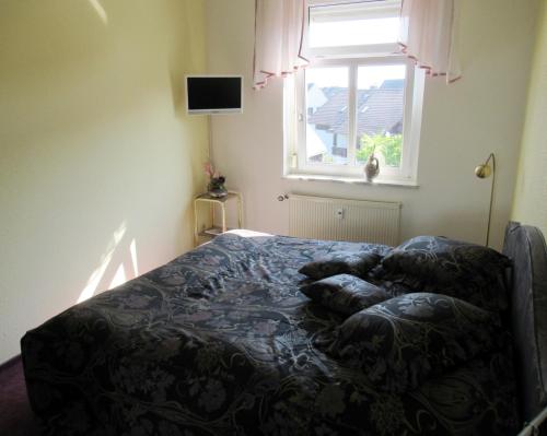 Bett in einem Schlafzimmer mit Fenster in der Unterkunft Urlaubsdomizil Lengefeld in Lengefeld