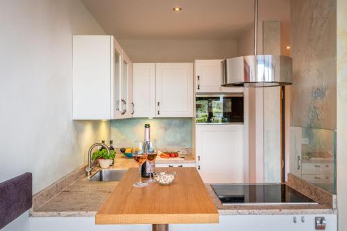 a kitchen with white cabinets and a wooden table at Lebensart am See in Bad Endorf
