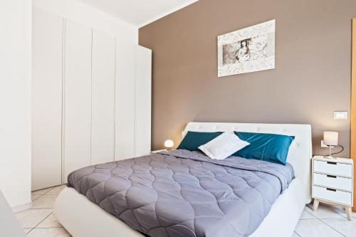 a bedroom with a large bed with blue pillows at Giardino Vignoli Functional Apartment in Bologna