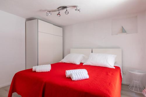 a bedroom with a red bed with two white pillows at Old Town Charming Nest in Dubrovnik