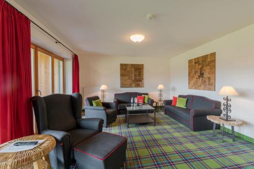 a living room with couches and chairs at Relais & Châteaux Gut Steinbach Hotel Chalets SPA in Reit im Winkl