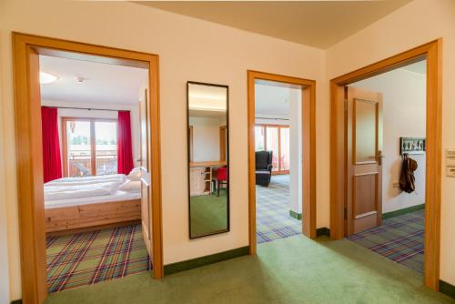 a room with a bed and a mirror at Relais & Châteaux Gut Steinbach Hotel Chalets SPA in Reit im Winkl