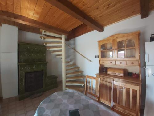 ein Wohnzimmer mit Treppe und Kamin in der Unterkunft Erdő szélén Házikó Gyenesdiás in Gyenesdiás