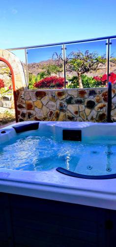 a jacuzzi tub in a yard with a chair at Casa Holmston, Duplex villa with hot tub in Anfi Tauro Topaz in Mogán
