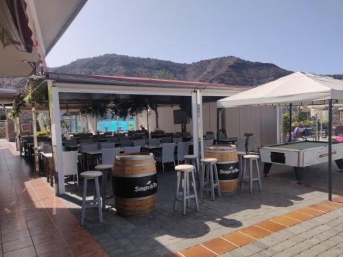 a bar with stools and a ping pong table at Casa Holmston, Duplex villa with hot tub in Anfi Tauro Topaz in Mogán