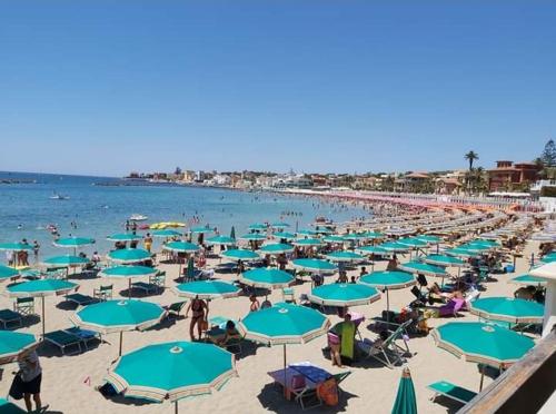 una playa llena de sombrillas azules en Il Vicoletto en Santa Marinella