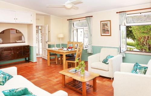 a living room with white furniture and a table at CASA BEACHCOMBER Le jardin des Arts in Lagos