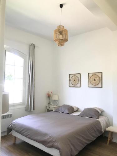 une chambre avec un grand lit et un lustre dans l'établissement Grand F2 quartier Les Plaines, Boulouris proche mer et port Santa-Lucia, à Saint-Raphaël