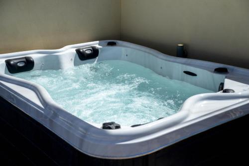 a bath tub filled with blue water in a room at Sunrise onLava in Oia
