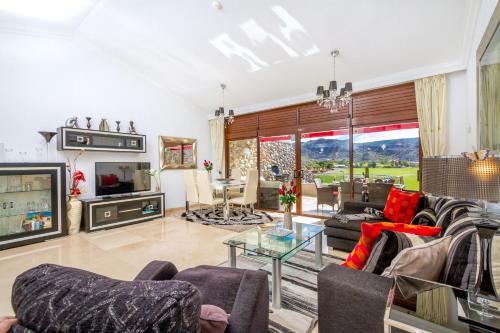 a living room filled with furniture and a tv at Casa Holmston, Duplex villa with hot tub in Anfi Tauro Topaz in Mogán