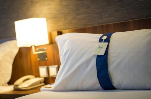 a bed with a pillow with a blue tie on it at Holiday Inn Express Lisboa - Av. Liberdade, an IHG Hotel in Lisbon