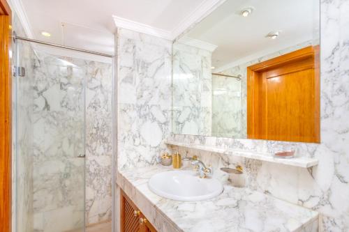 een badkamer met een wastafel en een douche bij Casa Holmston, Duplex villa with hot tub in Anfi Tauro Topaz in Mogán