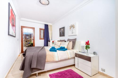 a white bedroom with a bed and a table at Casa Holmston, Duplex villa with hot tub in Anfi Tauro Topaz in Mogán