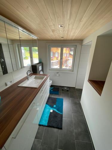 uma cozinha com um lavatório e um espelho em Haus Raid em Krumbach