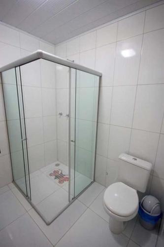 a bathroom with a glass shower with a toilet at Pousada Mama Pereira in Japaratinga