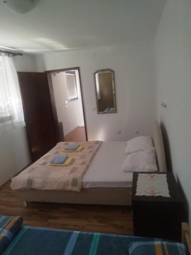 a bedroom with a large bed with a mirror and a mirror at Family apartman Ana - Star in Golubac
