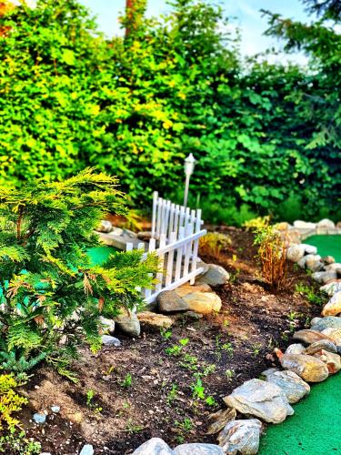 a white bench sitting in the middle of a garden at Pensiunea Apfelhaus in Cisnadioara