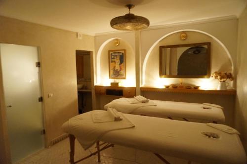 a bathroom with two beds and a mirror at Riad le Clos des Arts in Marrakech