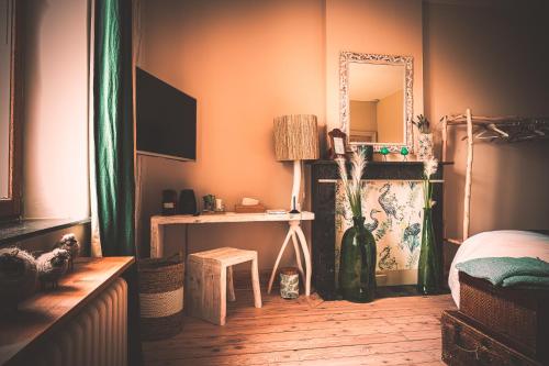 a bedroom with a bed and a table and a mirror at Le Jardin Des Secrets "Gites et chambres à louer" in Namur