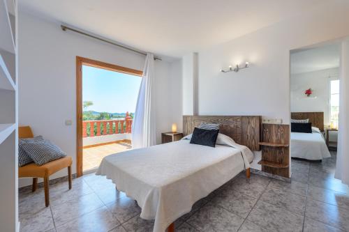 a bedroom with a bed and a balcony at Sa Carroca Villa in Sant Josep de Sa Talaia