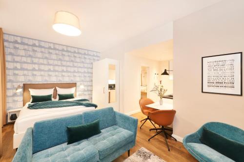 sypialnia z łóżkiem i niebieską kanapą w obiekcie ÜberFluss Serviced-Apartments w Bremie