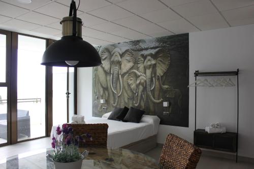 1 dormitorio con un mural de elefantes en la pared en Apartamentos Rurales El Mirador, en Córdoba