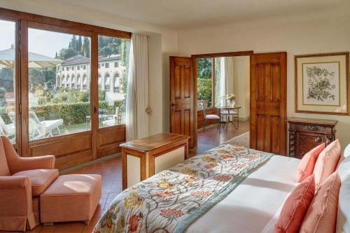 a bedroom with a bed and a chair and a window at Villa San Michele, A Belmond Hotel, Florence in Fiesole