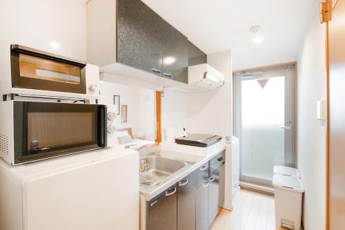 a small kitchen with a sink and a microwave at Viale Jurakumawari in Kyoto