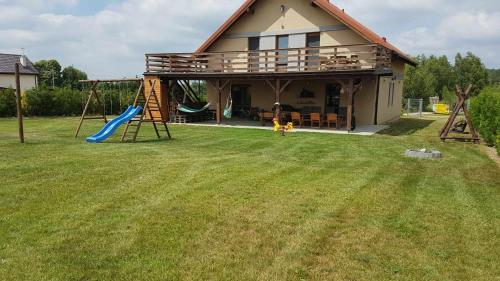 a house with a playground in the yard at Dom letniskowy Sieraków in Sieraków